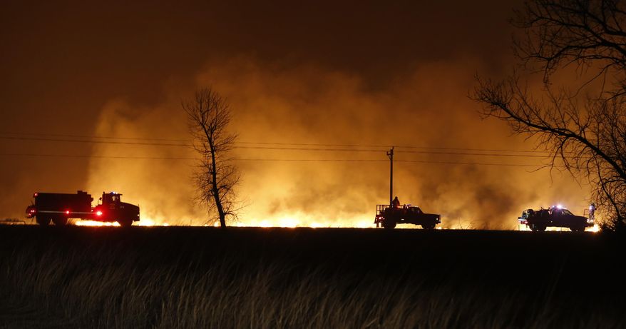 ADVANCE FOR WEEKEND EDITIONS MARCH 19, 2017 AND THEREAFTER - FILE - In this March 6, 2017, file photo, firefighters from across Kansas and Oklahoma battle a wildfire near Protection, Kan. When wildfires scorched more than 1 million acres in early March cross parts of the Texas Panhandle, Oklahoma and Kansas, weather forecasters used a new weather satellite to see the infernos developing, almost in real-time. (Bo Rader/The Wichita Eagle via AP, File)