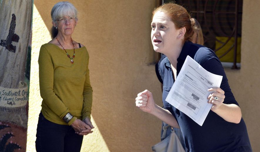 Bekah Wolf, center, of the National Lawyers Guild, acts as a federal immigration agent during a role playing exercise for activists in Albuquerque, N.M. on Wednesday, March 15, 2017. New Mexico activists are joining advocacy groups across the country in providing training to people seeking to help immigrants avoid deportation. The SouthWest Organizing Project hosted a training session Wednesday on accompanying immigrants to court and supporting them when immigration authorities arrive. (AP Photo/Russell Contreras)
