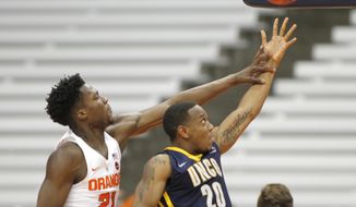 UNC Greensboro&#x27;s Diante Baldwin, right, shoots under pressure from Syracuse&#x27;s Tyler Roberson, left, during the second half of an NCAA college basketball game in the NIT in Syracuse, N.Y., Wednesday, March 15, 2017. Syracuse won 90-77. (AP Photo/Nick Lisi)
