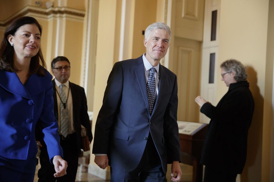 FILE - In this Feb. 2, 2107 file photo, Supreme Court Justice nominee Neil Gorsuch, right, escorted by former New Hampshire Sen. Kelly Ayotte walks on Capitol Hill in Washington. Despite strong endorsements from some gun rights advocates, Supreme Court nominee Neil Gorsuch has a sparse appeals court record on gun policy, one that leaves his view on how far the Second Amendment extends a judicial mystery. (AP Photo/J. Scott Applewhite, File)