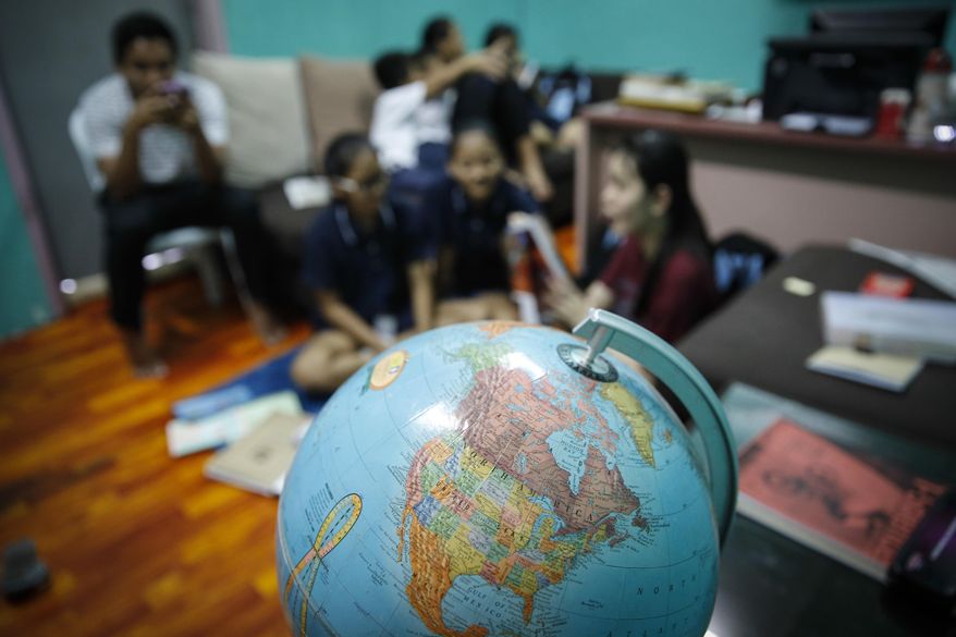 In this March 11, 2017, photo, Christian Burmese refugees sit in a classroom in Kuala Lumpur, Malaysia. An Associated Press analysis suggests that the people hurt most by President Donald Trump's planned deep cuts in refugee visas are from not any of the six Muslim countries listed in his travel ban, but Myanmar. (AP Photo/Joshua Paul)