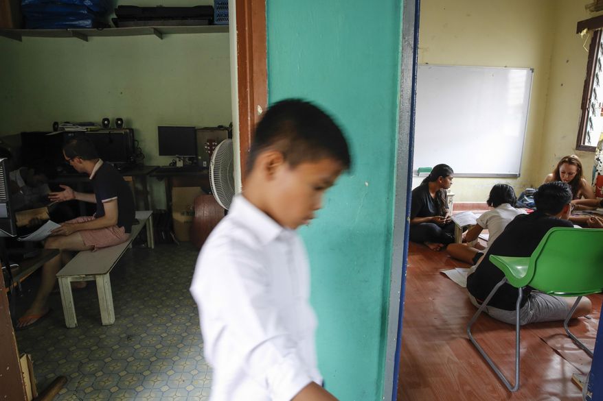 In this March 11, 2017, photo, a Christian Burmese refugee walks between two classrooms during lessons in Kuala Lumpur, Malaysia. An Associated Press analysis suggests that the people hurt most by President Donald Trump's planned deep cuts in refugee visas are from not any of the six Muslim countries listed in his travel ban, but Myanmar. (AP Photo/Joshua Paul)