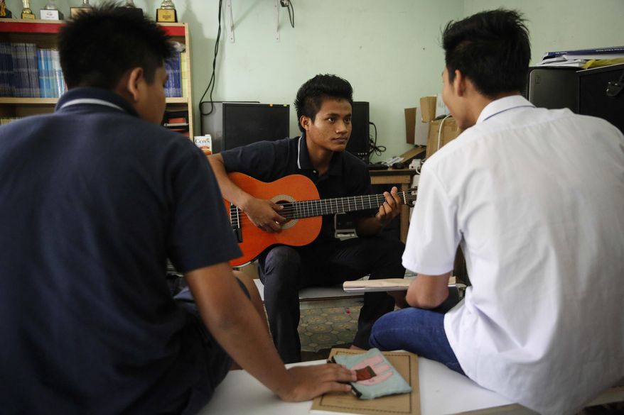 In this March 11, 2017, photo, Christian Burmese refugees play music in a classroom in Kuala Lumpur, Malaysia. An Associated Press analysis suggests that the people hurt most by President Donald Trump's planned deep cuts in refugee visas are from not any of the six Muslim countries listed in his travel ban, but Myanmar. (AP Photo/Joshua Paul)