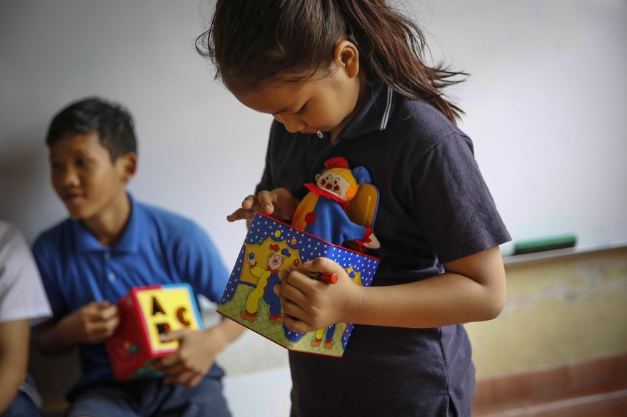 In this March 11, 2017, photo, Christian Burmese refugees play before the start of their lessons in Kuala Lumpur, Malaysia. An Associated Press analysis suggests that the people hurt most by President Donald Trump's planned deep cuts in refugee visas are from not any of the six Muslim countries listed in his travel ban, but Myanmar. (AP Photo/Joshua Paul)