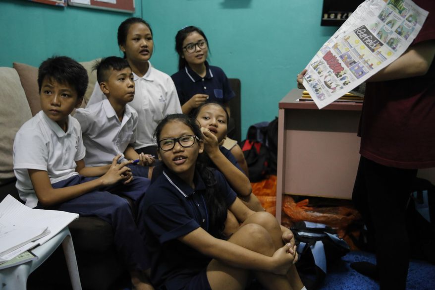 In this March 11, 2017, photo, Christian Burmese refugee students listen to a volunteer teacher during an English lesson in Kuala Lumpur, Malaysia. An Associated Press analysis suggests that the people hurt most by President Donald Trump's planned deep cuts in refugee visas are from not any of the six Muslim countries listed in his travel ban, but Myanmar. (AP Photo/Joshua Paul)