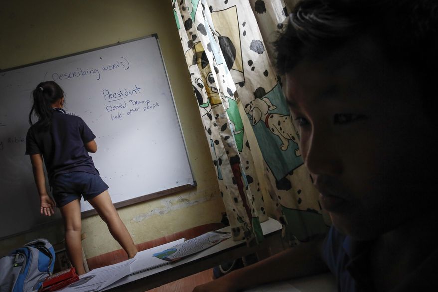 In this March 11, 2017, photo, a Christian Burmese refugee writes during an English lesson in Kuala Lumpur, Malaysia. An Associated Press analysis suggests that the people hurt most by President Donald Trump's planned deep cuts in refugee visas are from not any of the six Muslim countries listed in his travel ban, but Myanmar. (AP Photo/Joshua Paul)
