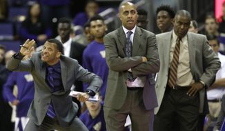 FILE - In this Jan. 18, 2017, file photo, Washington coach Lorenzo Romar, center, stands with assistant coach Michael Porter, right, as assistant coach Will Conroy signals to players during the team&#39;s NCAA college basketball game against Colorado in Seattle. Washington announced Wednesday, March 15, 2017, that Romar had been fired after 15 seasons at the school. (AP Photo/Ted S. Warren, file)