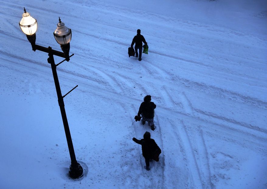 Pedestrians cross a snow-filled street to get to a hotel during a snowstorm in Lewiston, Maine, Tuesday, March 14, 2017. A blustery late-season storm is hitting the Northeast, closing schools and prompting dire warnings to stay off the roads. (AP Photo/David Goldman)
