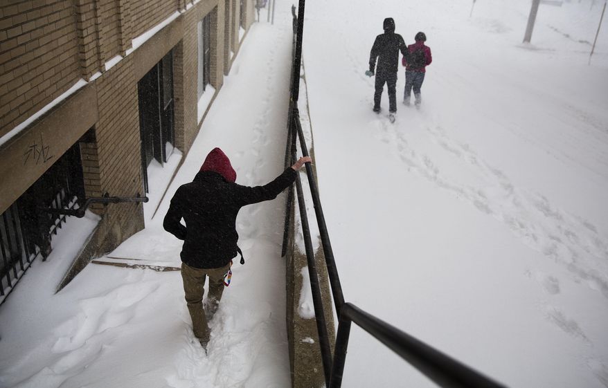 Pedestrians walk through a snowstorm in Lewiston, Maine, Tuesday, March 14, 2017. A blustery late-season storm is hitting the Northeast, closing schools and prompting dire warnings to stay off the roads. (AP Photo/David Goldman)