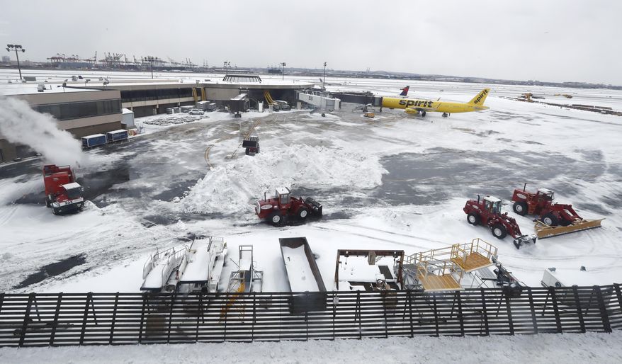 Front loaders, center, work on a mound of snow near gates at Newark Liberty International Airport a day after a snowstorm hit the region, Wednesday, March 15, 2017, in Newark, N.J. Plunging temperatures ushered in by the storm that plastered the Northeast turned the snow and sleet into rock-solid ice, leaving roads and sidewalks treacherous. (AP Photo/Julio Cortez)