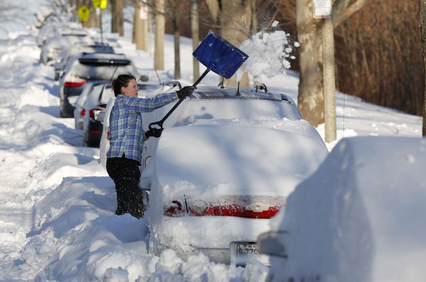 A woman digs her car out the morning after a powerful nor'easter buffeted much of the Northeast with blizzard conditions, Wednesday, March 15, 2017 in Portland, Maine. Falling temperatures are leading to icy conditions on roads and sidewalks across the Northeast following a late-season storm that plastered the region with sleet and snow.(AP Photo/Robert F. Bukaty)