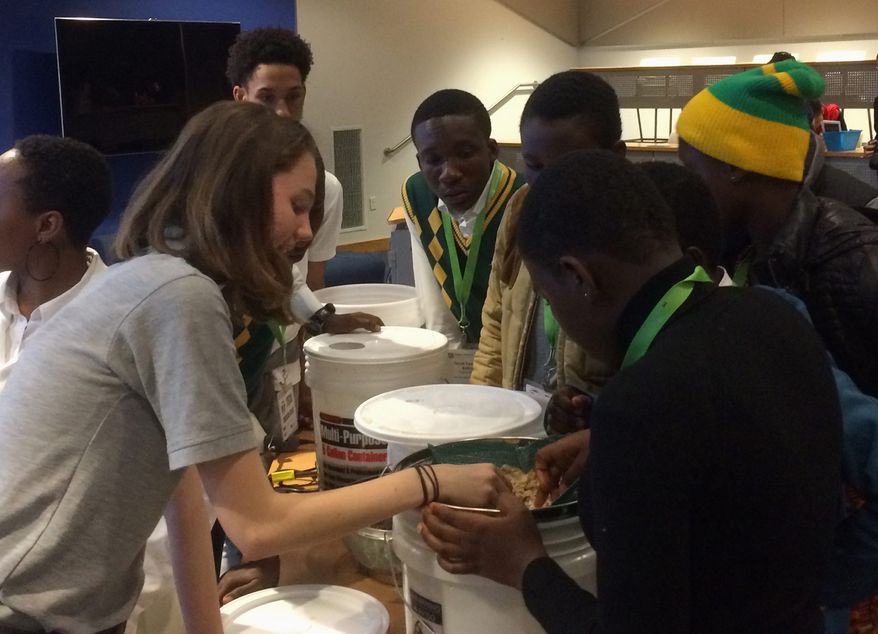Students from McKinley Technology High School in the District and Winneba High School in Ghana work on their prototype water filtration system, part of a virtual student exchange program focused on STEM education. (Julia Brouillette/The Washington Times)