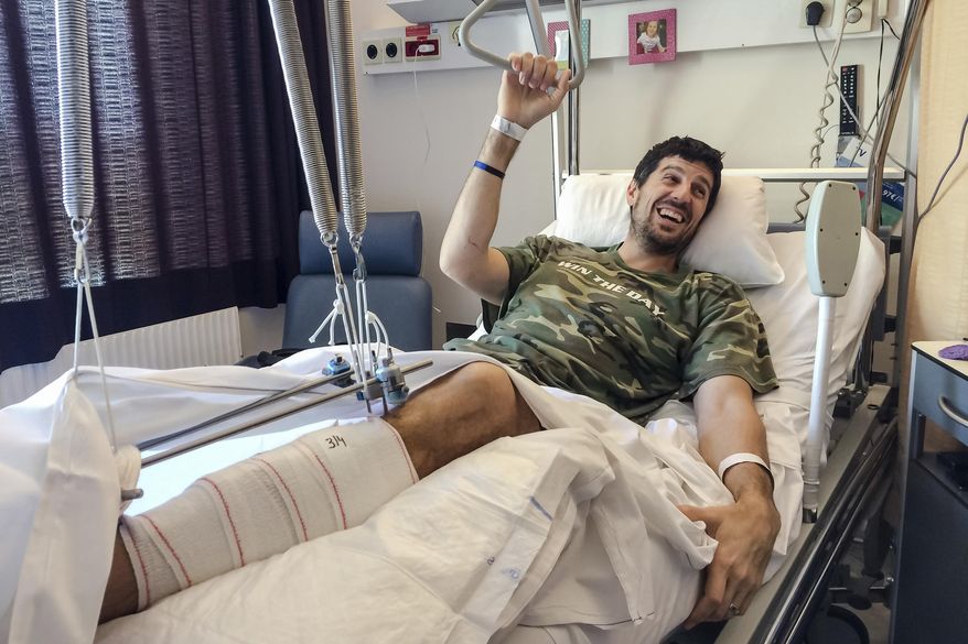 FILE - In this photo taken on Sunday, April 3, 2016, Belgian former professional basketball player Sebastien Bellin rests in his bed in Erasmus University Hospital in Brussels. The former basketball player, badly hurt in the suicide bomb attack on Brussels airport a year ago is urging the Belgian government to live up to its pledge to help the victims. (AP Photo/Helene Franchineau, File)