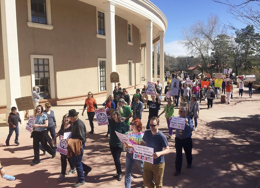 A rally in support of greater state funding for public education in New Mexico drew hundreds of teachers, parents and students to the state Capitol in Santa Fe, N.M., Thursday, March 16, 2017. Sign-waving protesters paced around the circular state Capitol building to chants of "no more cuts" and "save our schools." Santa Fe Public Schools Superintendent and former state education secretary Veronica Garcia canceled classes at mid-day so that staff and students could urge lawmakers and the governor to bolster spending on K-12 schools for the coming school year. (AP Photo/Morgan Lee)