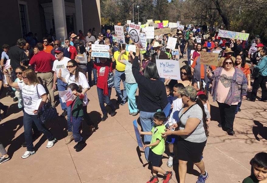 A rally in support of greater state funding for public education in New Mexico drew hundreds of teachers, parents and students to the state Capitol in Santa Fe, N.M., Thursday, March 16, 2017. Sign-waving protesters paced around the circular state Capitol building to chants of "no more cuts" and "save our schools." Santa Fe Public Schools Superintendent and former state education secretary Veronica Garcia canceled classes at mid-day so that staff and students could urge lawmakers and the governor to bolster spending on K-12 schools for the coming school year. (AP Photo/Morgan Lee)