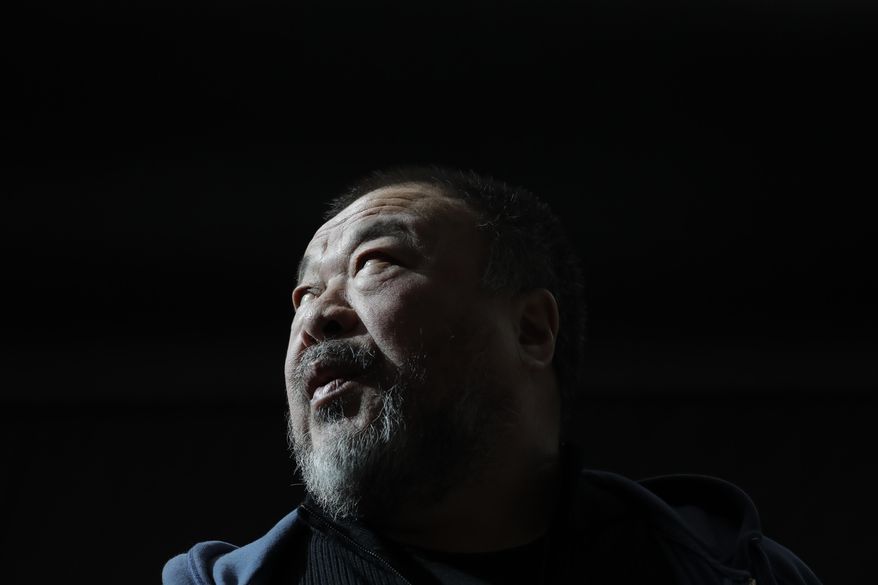 Chinese activist and artist Ai Weiwei holds a press conference at the National Gallery in Prague, Czech Republic, Thursday, March 16, 2017. Ai weiwei has prepared for the gallery a 70-metre-long inflatable boat with life-size figures of 258 refugees, called "The Law of the Journey," and it is one of the artist's biggest work of art so far. (AP Photo/Petr David Josek)