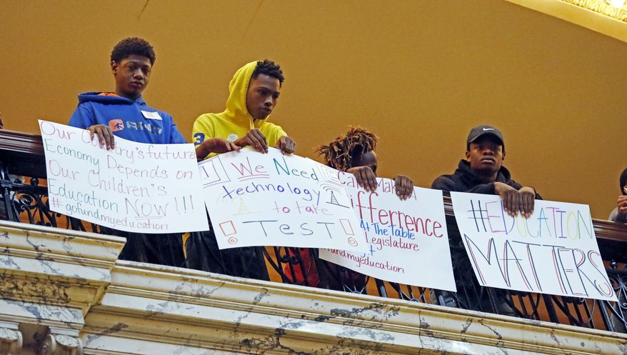 Students holds up signs, joining several hundred parents, educators, education activists, and a handful of legislators in an education rally at the Capitol in Jackson, Miss., Thursday, March 16, 2017. Advocates for public schools are opposing legislative leaders' plans to rewrite the state's school funding formula. (AP Photo/Rogelio V. Solis)