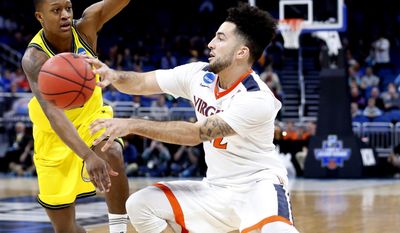 Virginia guard London Perrantes, right, passes past UNC Wilmington guard C.J. Bryce during the first round of the NCAA college basketball tournament, Thursday, March 16, 2017 in Orlando, Fla. (AP Photo/Wilfredo Lee)