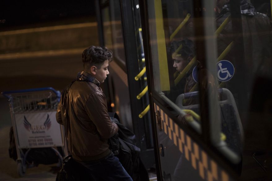 Oraha, 12, boards a bus in the Erbil International Airport in Irbil, Iraq, Wednesday, March 15, 2017. An Iraqi family has landed in the United States as a federal court blocked a travel ban that would have kept others like them out of the country for 120 days. Nadia Hanan Madalo and her family arrived in San Diego to be reunited with Madalo’s siblings and mother, who arrived as refugees in recent years. (AP Photo/Felipe Dana)