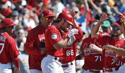 St. Louis Cardinals&#39; Randal Grichuk (15), center, is mobbed by his teammates after driving in the game-winning run with a single in the ninth inning of a spring training baseball game against the Minnesota Twins Thursday, March 16, 2017, in Jupiter, Fla. (AP Photo/John Bazemore)