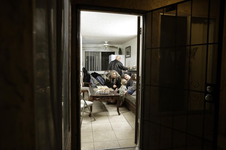 Nadia Hanan Madalo, center, talks with family members as she sits in her brother's apartment Thursday, March 16, 2017, in El Cajon, Calif, after arriving to the United States. Madalo and her family, refugees forced to flee their town of Batnaya, Iraq, after the Islamic State invaded and destroyed it several years ago, arrived in San Diego to be reunited with Madalo's siblings and mother. As they flew to the U.S. on Wednesday, a federal judge in Hawaii put a hold on President Trump's newest ban - the latest development in a fight between the administration and the courts that has injected more uncertainty into the lives of refugees. (AP Photo/Gregory Bull)
