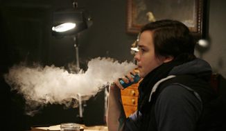 JUULing sends a rush of nicotine into the system from the company&#39;s unique liquid formula. (Associated Press/File) 