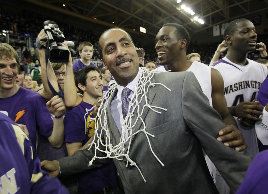 FILE - In this March 7, 2009 file photo, Washington coach Lorenzo Romar wears the net after he cut it from the rim as he celebrates with his team after Washington defeated Washington State 67-60 in an NCAA college basketball game to win the Pac-10 championship in Seattle. Washington announced Wednesday, March 15, 2017, that Romar had been fired after 15 seasons at the school. (AP Photo/Ted S. Warren, file)