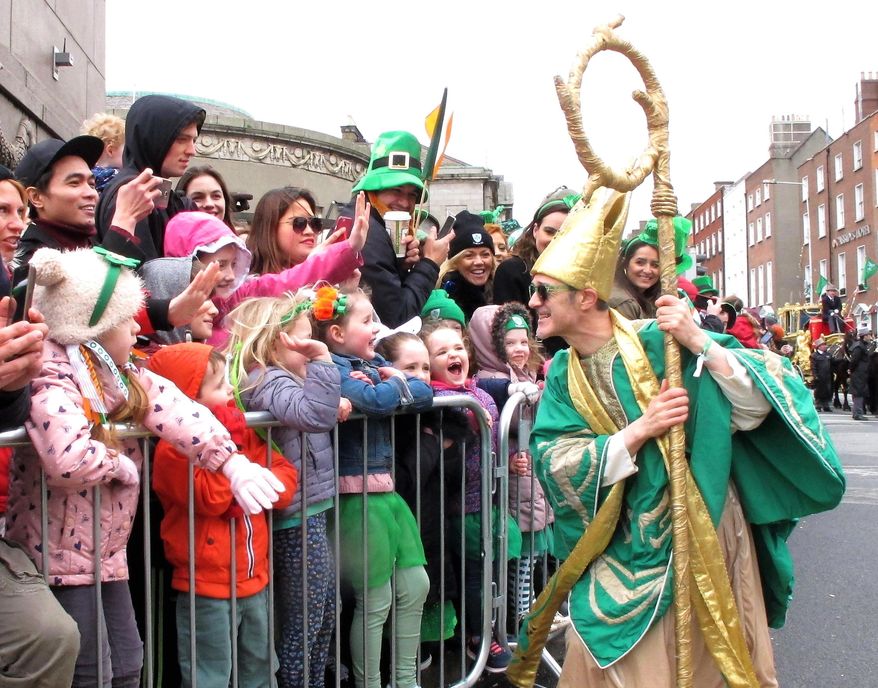 Saint Patrick as portrayed by Irish actor Johnny Murphy clowns around with children watching the St. Patrick’s Day parade in Dublin, Ireland, Friday, March 17, 2017. An estimated half million tourists and Dubliners watched the parade, the focal point for a four-day festival that marks the start of Ireland's tourist season. (AP Photo/Shawn Pogatchnik)