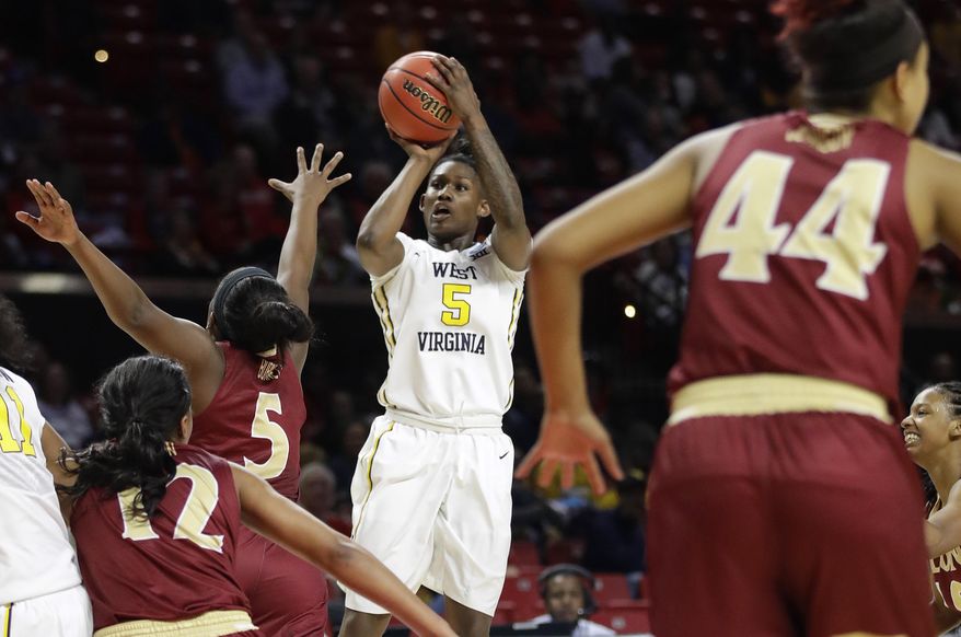West Virginia guard Tynice Martin (5) shoots over a group of Elon defenders in the first half of a first-round game in the women's NCAA college basketball tournament in College Park, Md., Friday, March 17, 2017. (AP Photo/Patrick Semansky)