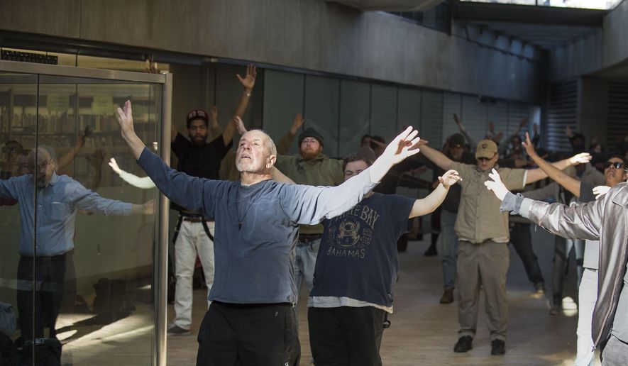 In a Thursday, March 2, 2017 photo, Bernie Hart leads a group of homeless people in tai chi at the Salt Lake City Public Library. Hart hopes that the slow-paced practice of balance and movement will help these individuals find stability in their lives. The activist started the informal program with his wife, Marita, in September. (Lennie Mahler/The Salt Lake Tribune via AP)