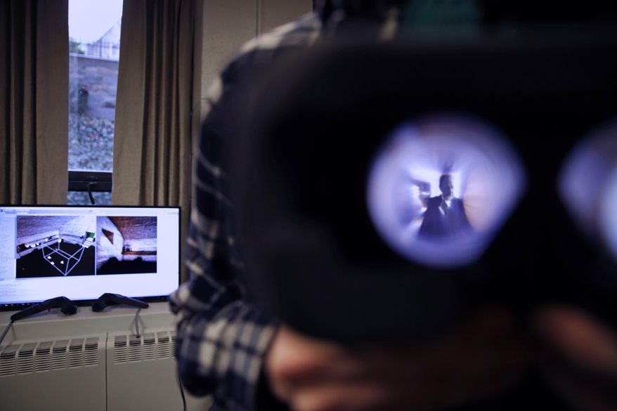 In this Jan. 26, 2017, photo, Boston College student Michael Quinn holds up virtual reality goggles at a virtual reality lab at Boston College in Boston. College students in Boston are developing a virtual reality game based on James Joyce’s ponderous tome “Ulysses.” (AP Photo/Charles Krupa)