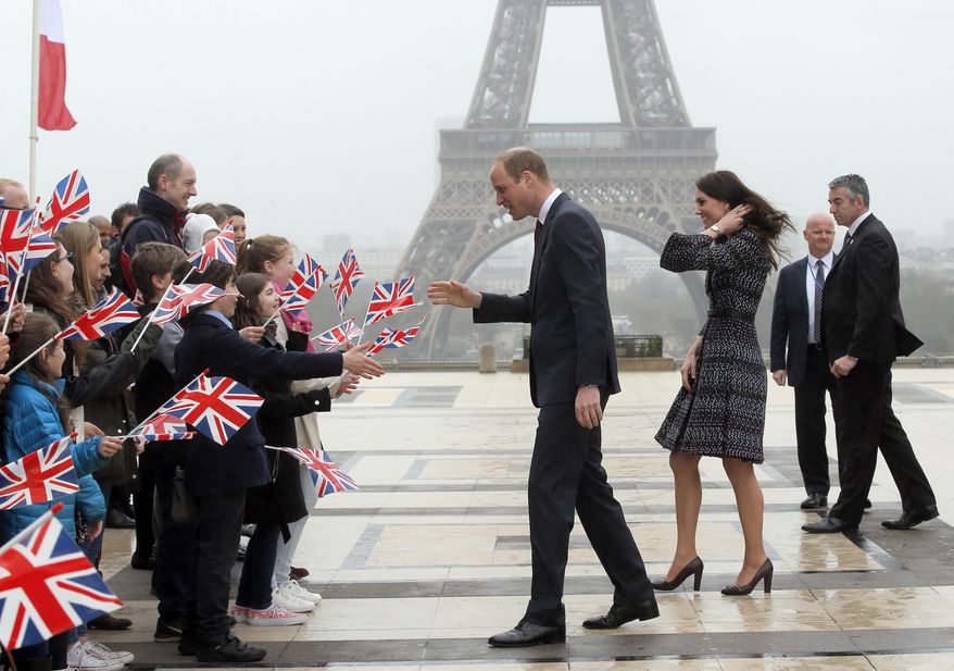 Britain's Prince William, the Duke of Cambridge, and his wife Kate, the Duchess of Cambridge, are welcomed by school children and students from the British Council's Somme project as they arrive at the Trocadero square, with the Eiffel Tower in background, in Paris, Saturday, March 18, 2017. (AP Photo/Michel Euler, Pool)