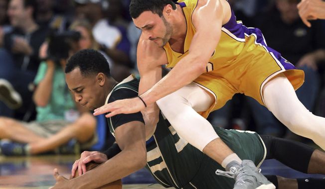 Milwaukee Bucks center John Henson, left, and Los Angeles Lakers forward Larry Nance Jr. tangle on the floor during the first half of an NBA basketball game in Los Angeles on Friday, March 17, 2017. (AP Photo/Reed Saxon)