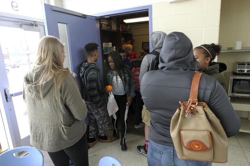ADVANCE FOR SATURDAY MARCH 18 AND THEREAFTER - In a Friday, March 3, 2017 photo, Deanna Toro, 17, leaves Tate High School's food pantry with fruit and other food after school in Iowa City. (Holly Hines/Iowa City Press-Citizen via AP)