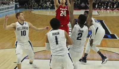 Wisconsin guard Bronson Koenig (24) takes a jump shot while defended by Villanova guard Donte DiVincenzo (10), guard Jalen Brunson (1) and forward Kris Jenkins (2) during the second half of a second-round men&#x27;s college basketball game in the NCAA Tournament, Saturday, March 18, 2017, in Buffalo, N.Y. (AP Photo/Bill Wippert)