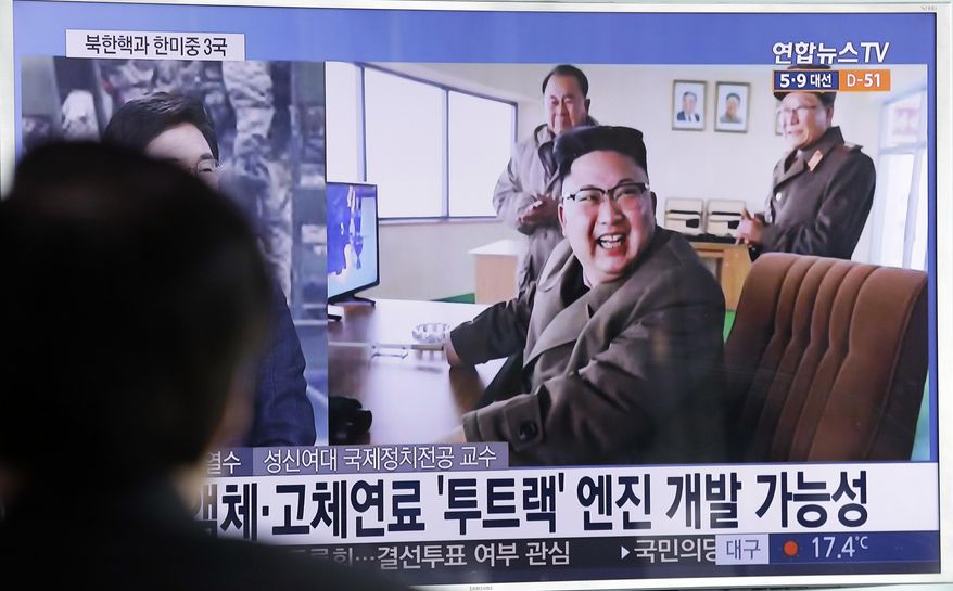 A man watches a TV news program showing an image, published in North Korea's Rodong Sinmun newspaper, of North Korean leader Kim Jong Un at the country's Sohae launch site, at Seoul Railway station in Seoul, South Korea, Sunday, March 19, 2017. North Korea has conducted a ground test of a new type of high-thrust rocket engine that leader Kim Jong Un is calling a revolutionary breakthrough for the country's space program. The letters read " New type engine." (AP Photo/Ahn Young-joon)