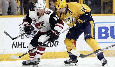 Arizona Coyotes left wing Jamie McGinn (88) and Nashville Predators center Mike Fisher (12) battle for the puck during the first period of an NHL hockey game Monday, March 20, 2017, in Nashville, Tenn. (AP Photo/Mark Humphrey)