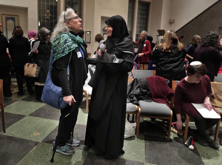 In this Thursday, Feb. 16, 2017 photo, members of the Sisterhood Salaam Shalom talk after a unity vigil held at the Jewish Theological Seminary in New York. The Sisterhood of Salaam Shalom, a national organization that brings together Muslim and Jewish women, organized the gathering as part of the organization's response to President Donald Trump's travel ban. (AP Photo/Julie Jacobson)