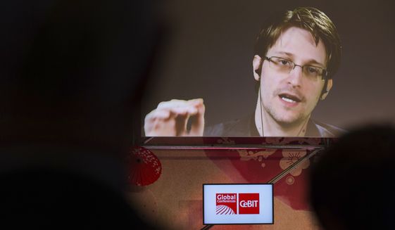 Edward Snowden, a former CIA worker before turning whistleblower, speaks via satellite at the IT fair CeBIT in Hanover, Germany, Tuesday March 21,  2017. ( Friso Gentsch/dpa via AP)