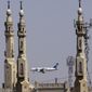 FILE - In this May 21, 2016, file photo, an EgyptAir plane flies past minarets of a mosque as it approaches Cairo International Airport, in Cairo, Egypt. A new U.S. security measure targeting flights from eight mostly Muslim countries is leading travelers to reconsider their plans to fly through some airports in the Middle East. An electronics ban affects flights from international airports to the U.S. from in Amman, Jordan; Kuwait City, Kuwait; Cairo; Istanbul; Jeddah and Riyadh, Saudi Arabia; Casablanca, Morocco; Doha, Qatar; and Dubai and Abu Dhabi in the United Arab Emirates. (AP Photo/Amr Nabil, File)