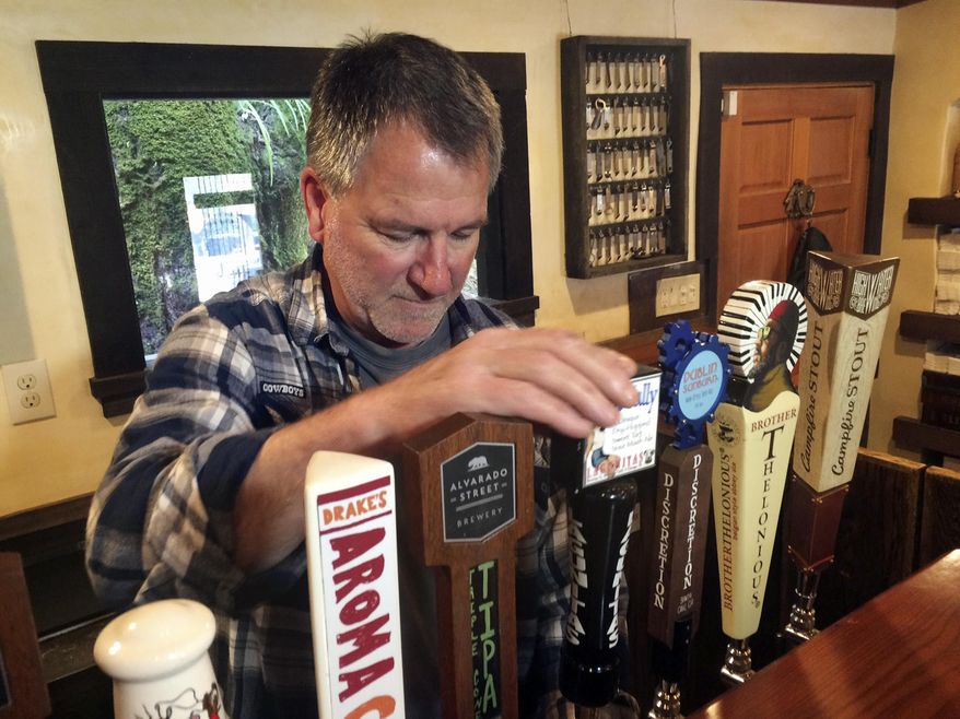 In this March 16, 2017, photo, Big Sur Taproom and Deli owner Kurt Mayer pours a beer in Big Sur, Calif. The tap room and deli are the only businesses open in town on the south side of the bridge closure on Highway 1. Mayer has to drive six hours round trip back to Monterey to keep the general store and bar stocked. (AP Photo/Haven Daley)