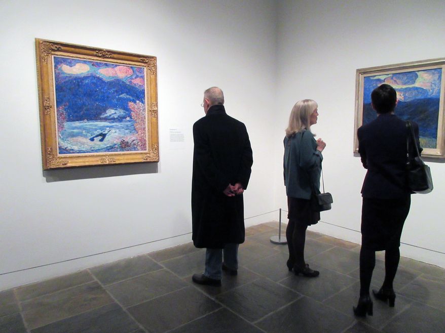 This March 20, 2017 photo shows visitors looking at paintings from the "Marsden Hartley's Maine" show at The Met Breuer Museum in New York. Hartley was a native of Maine and the exhibition showcases his landscapes and portraits of Maine. Maine's tourism agency has created itineraries that match the artwork for travelers who'd like to visit the places depicted in the paintings. (AP Photo/Beth J. Harpaz)