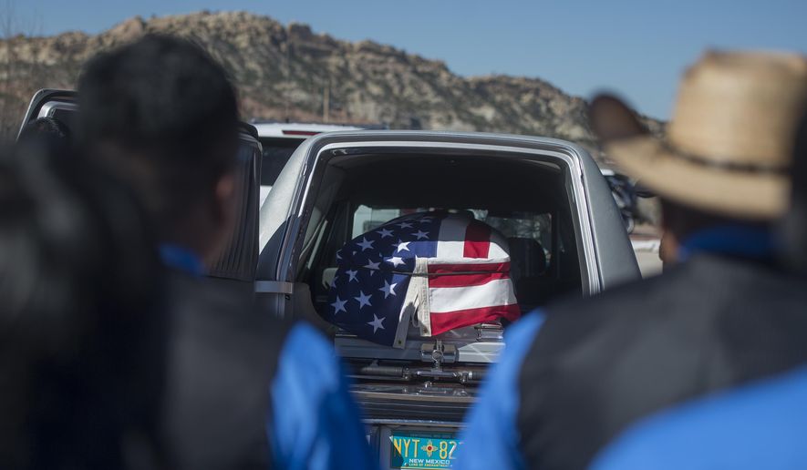 FILE--In this March 16, 2017, file photo, family members of fallen Navajo Nation police officer Houston Largo wear blue in his honor and stand by to wait for his casket to be removed from the hearse during funeral services in Gallup, N.M. Largo, a Navajo Nation police officer, was shot while responding to a domestic violence call in remote New Mexico. Investigators say the man accused of killing Largo had spent the afternoon drinking and was intoxicated the night of the shooting. (Cayla Nimmo/Gallup Independent via AP, file)