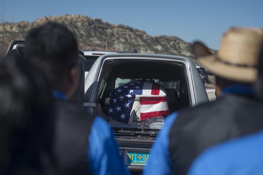 FILE--In this March 16, 2017, file photo, family members of fallen Navajo Nation police officer Houston Largo wear blue in his honor and stand by to wait for his casket to be removed from the hearse during funeral services in Gallup, N.M. Largo, a Navajo Nation police officer, was shot while responding to a domestic violence call in remote New Mexico. Investigators say the man accused of killing Largo had spent the afternoon drinking and was intoxicated the night of the shooting. (Cayla Nimmo/Gallup Independent via AP, file)