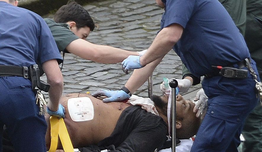 An attacker is treated by emergency services outside the Houses of Parliament London, Wednesday, March 22, 2017.  London police say they are treating a gun and knife incident at Britain&#39;s Parliament &amp;quot;as a terrorist incident until we know otherwise.&amp;quot; The Metropolitan Police says in a statement that the incident is ongoing. It is urging people to stay away from the area. Officials say a man with a knife attacked a police officer at Parliament and was shot by officers. Nearby, witnesses say a vehicle struck several people on the Westminster Bridge.  (Stefan Rousseau/PA via AP).