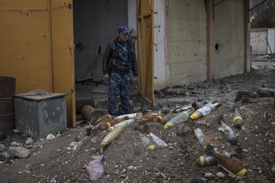 A Federal Police stands next to unexploded bombs left by Islamic State militants on the western side of Mosul, Iraq, Wednesday, March 22, 2017. (AP Photo/Felipe Dana)