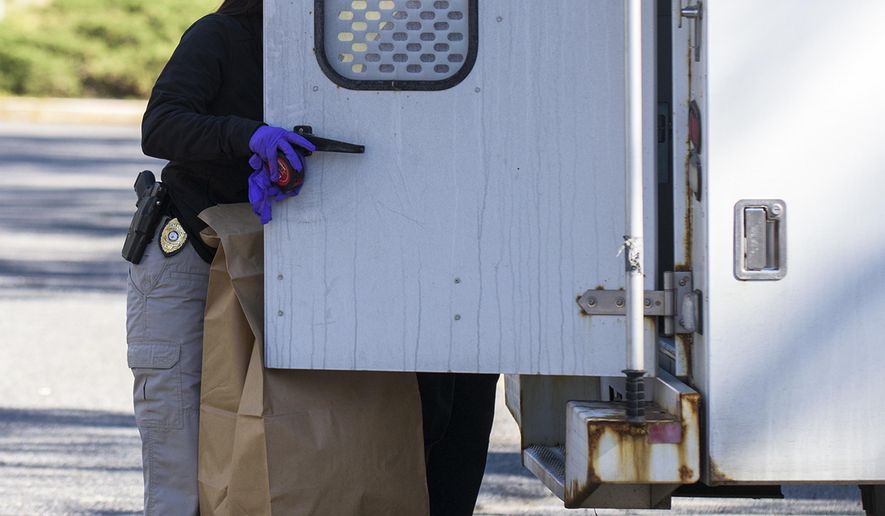 Authorities load evidence bags into a truck at the scene where two infants were found dead Wednesday, March 22, 2017, at the Pines Apartments in Lindenwold, N.J. An investigation is underway. (Joe Lamberti/Camden Courier-Post via AP)