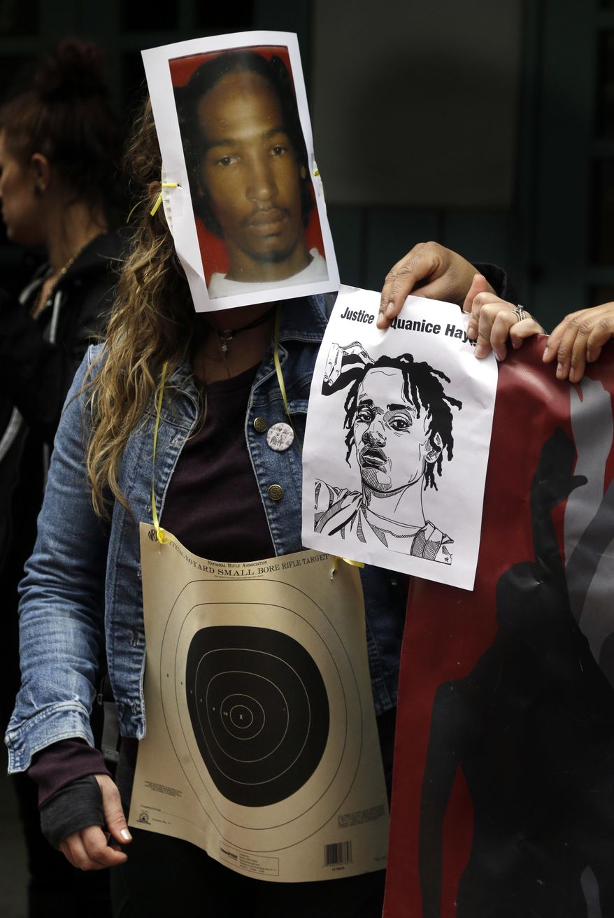 A person wears a bullseye and photo mask of Quanice Hayes during a press conference in Portland, Ore., Wednesday, March 22, 2017. Venus Hayes, the mother the 17-year-old Quanice Hayes, held the news conference after a grand jury declined to indict a Portland police officer on criminal charges in the Feb. 9, 2017, shooting death of her son and is demanding a federal investigation. (AP Photo/Don Ryan)