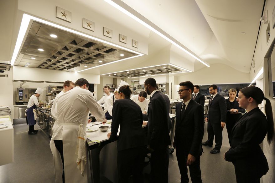 In this photo taken Thursday, March 9, 2017, servers gather around the pass to pick up servings inside the new kitchen at the French Laundry restaurant in Yountville, Calif. Celebrated chef Thomas Keller has just opened a state-of-the art new kitchen at his famed French Laundry after spending $10 million on an extensive renovation. (AP Photo/Eric Risberg)