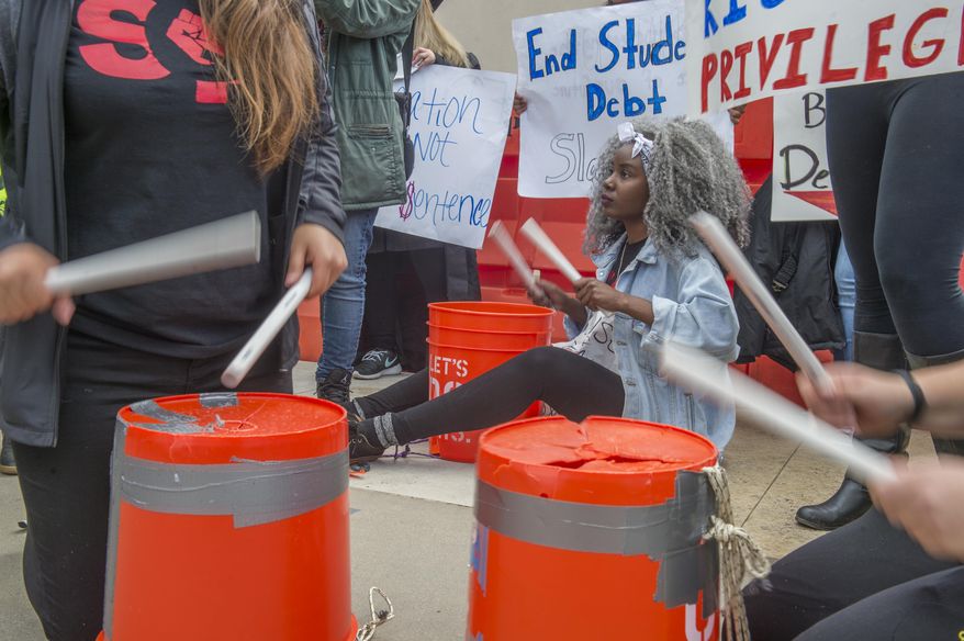 Shiba Bandeeba, of San Fransico State, plays the bucket at a protest with other students and supporters outside of the California State University Office of the Chancellor as the CSU Trustees finance committee vote on a tuition increase on a 7 to 2 vote in Long Beach Wednesday, March 22, 2017. (Thomas R. Cordova/Los Angeles Daily News via AP)